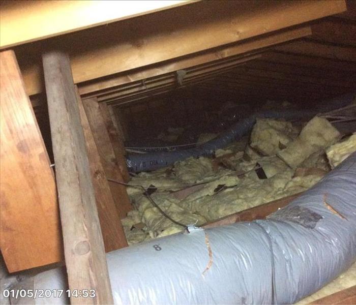 view of attic crawl with disheveled  rolled insulation, debris, and ripped ductwork