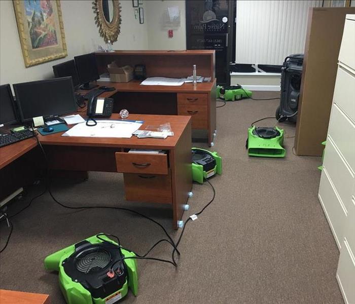 office desks, filing cabinets, and equipment drying the brown carpet