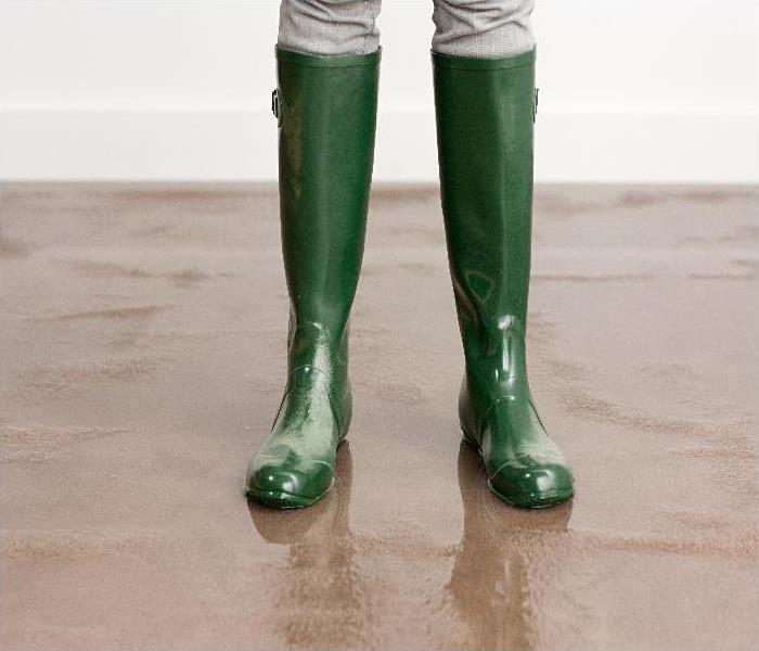 Woman in wellington boots on flooded floor