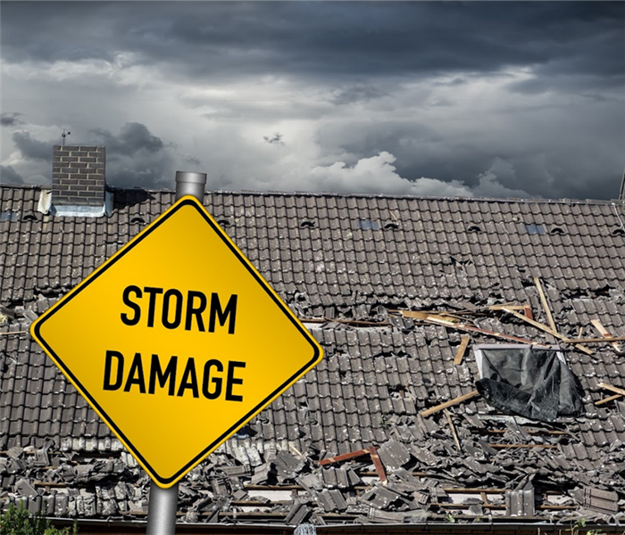 a storm damaged house with a yellow storm damage sign in front of it